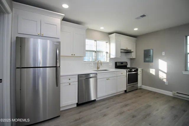 a kitchen with stainless steel appliances granite countertop a refrigerator sink and cabinets