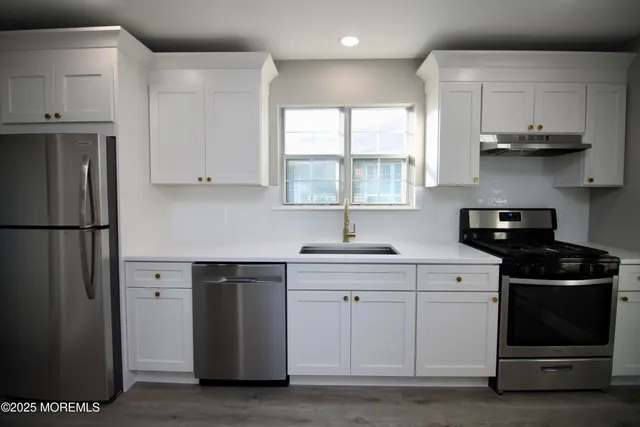 a kitchen with stainless steel appliances granite countertop a stove a refrigerator and a sink