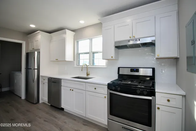 a kitchen with stainless steel appliances a stove a sink and a refrigerator