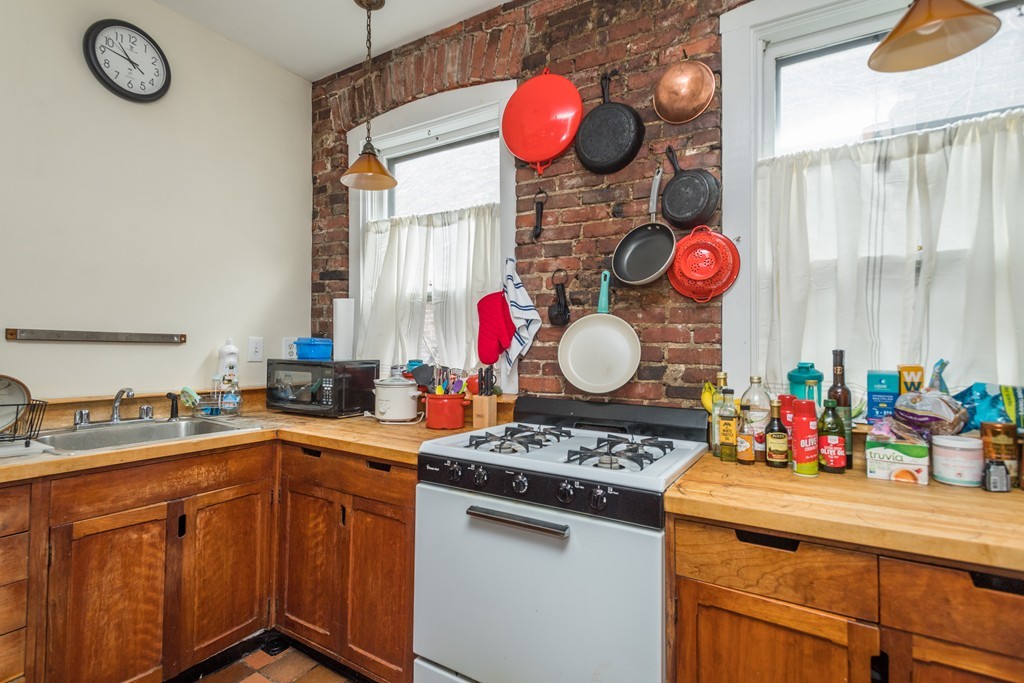 20 Grove Street Boston, MA 02114 - Photo 16 of 29 a kitchen with granite countertop a sink a stove and a window