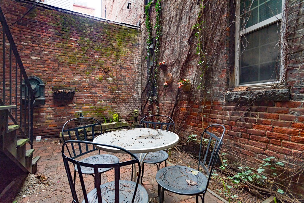 20 Grove Street Boston, MA 02114 - Photo 19 of 29 a backyard of a house with table and chairs