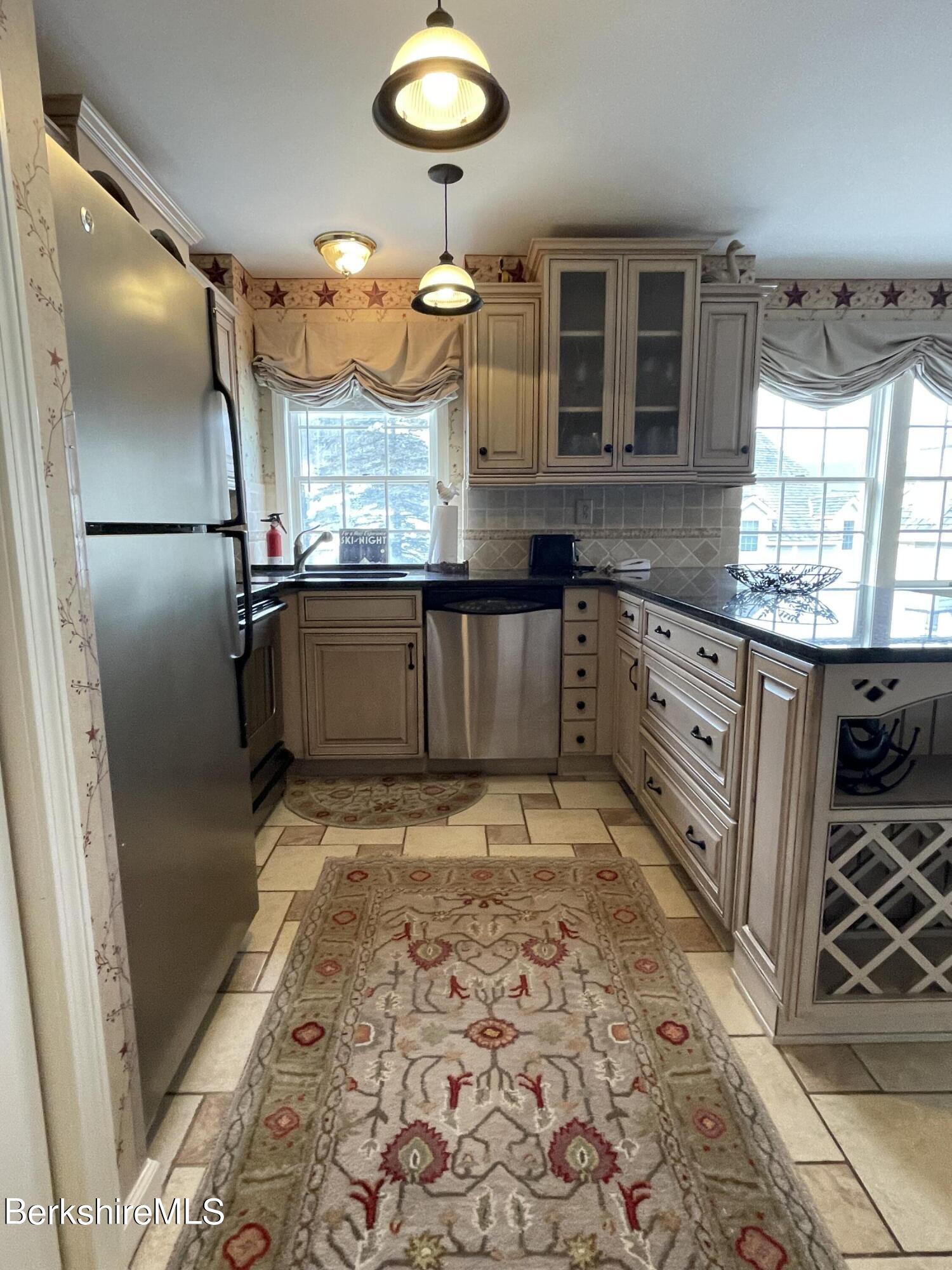 37 Corey Road, Unit 822 Hancock, MA 01237 - Photo 11 of 25 a kitchen with granite countertop a refrigerator and a stove