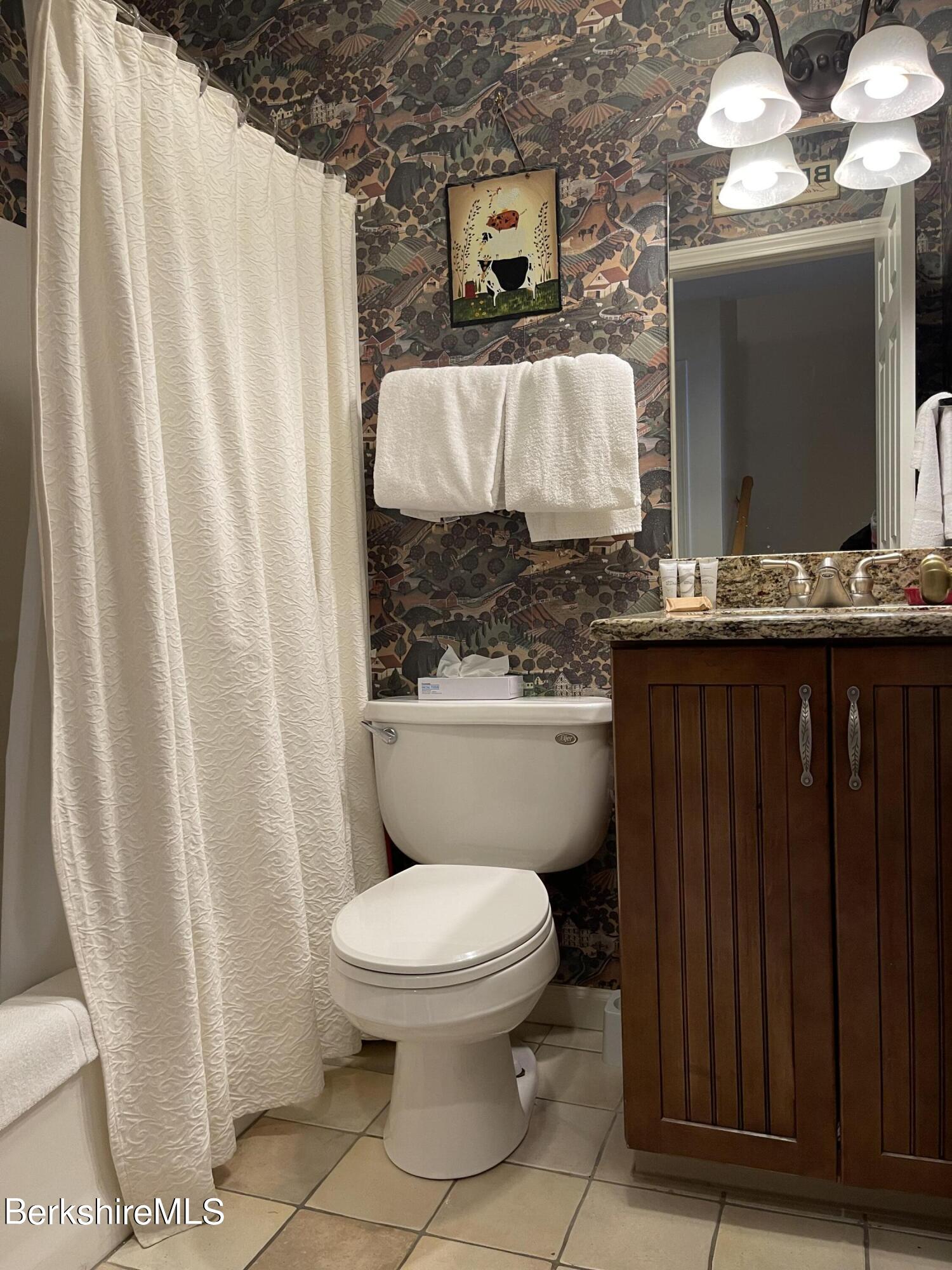 37 Corey Road, Unit 822 Hancock, MA 01237 - Photo 6 of 25 a bathroom with a granite countertop toilet sink and mirror
