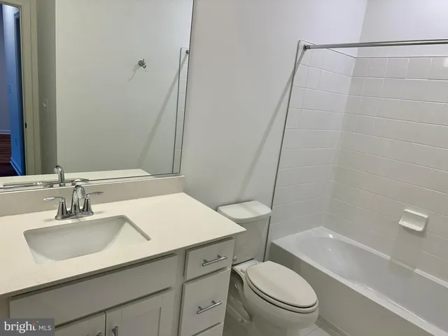 a bathroom with a sink a toilet a mirror and shower