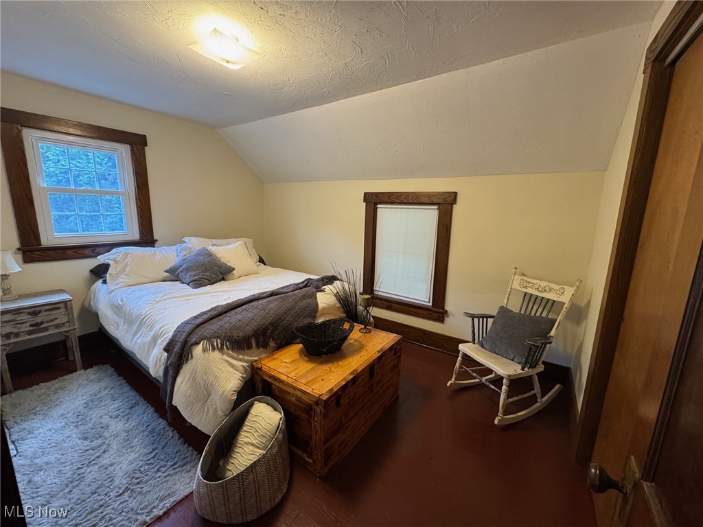 5322 Lockwood Road Madison, OH 44057 - Photo 16 of 30 Bedroom featuring vaulted ceiling, wood finished floors, and a textured ceiling