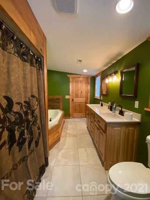 5281 Jenkins Road Morganton, NC 28655 - Photo 15 of 31 a bathroom with a double vanity sink a toilet a mirror and shower