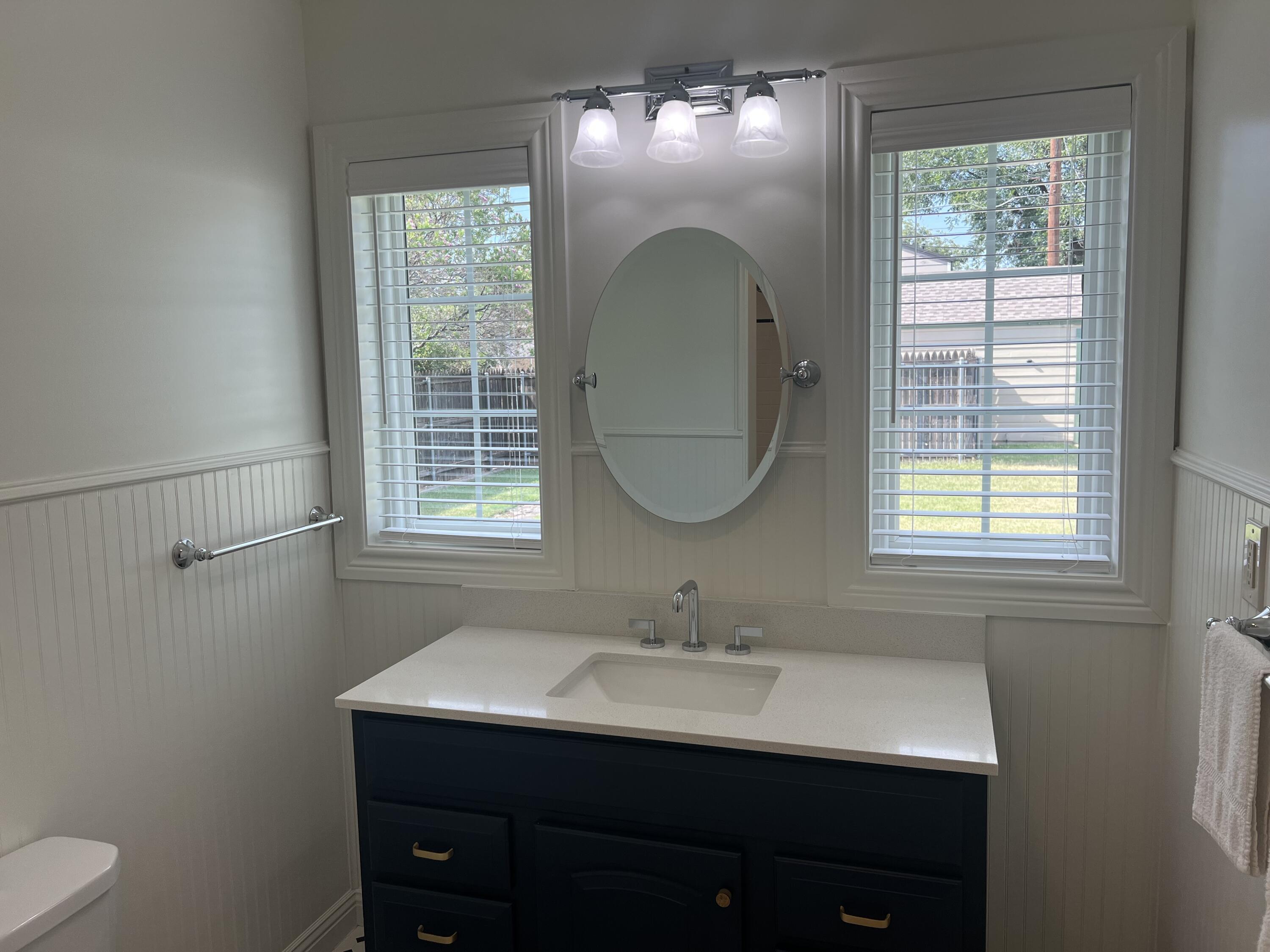 2916 21st Street Lubbock, TX 79410 - Photo 19 of 28 a bathroom with a sink mirror and window