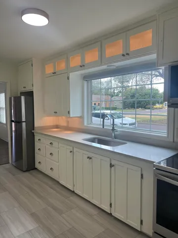 a kitchen with granite countertop a sink and a refrigerator