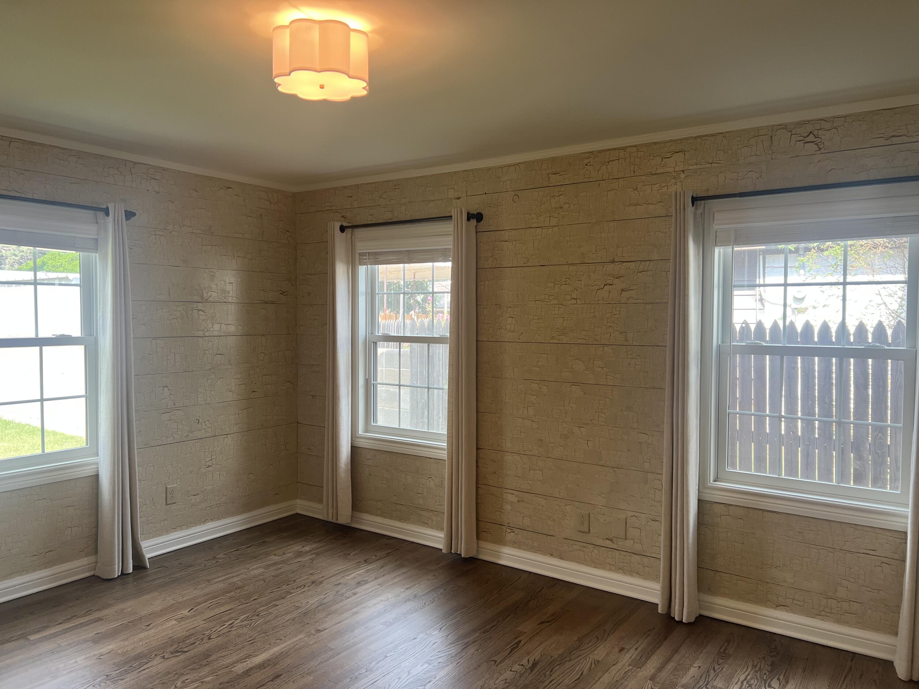 2916 21st Street Lubbock, TX 79410 - Photo 22 of 28 an empty room with wooden floor fan and windows