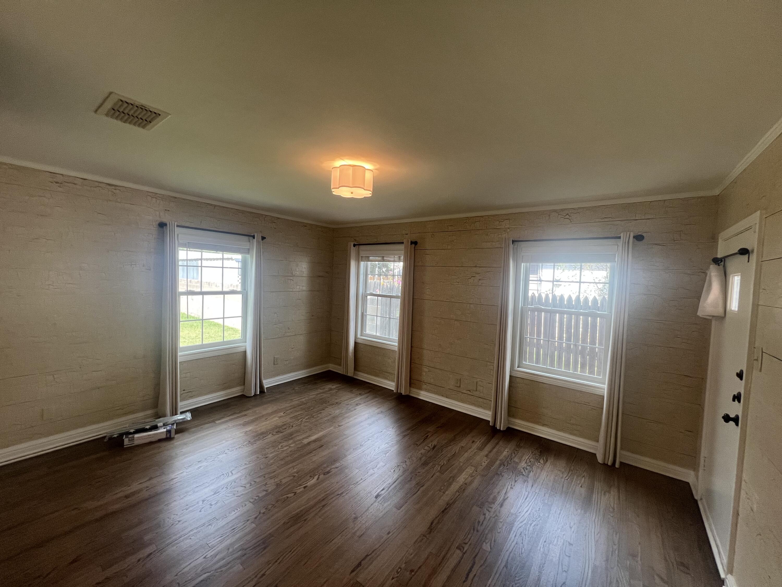 2916 21st Street Lubbock, TX 79410 - Photo 26 of 28 an empty room with wooden floor and windows