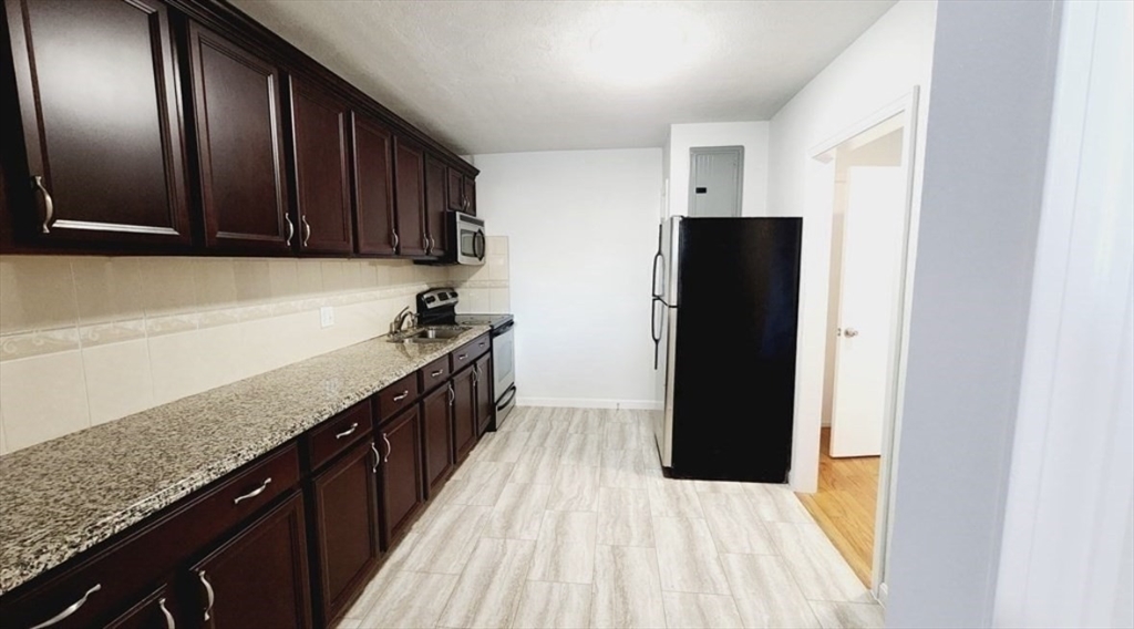 116 Spring Street, Unit D2 Boston, MA 02132 - Photo 2 of 9 a kitchen with a sink and refrigerator