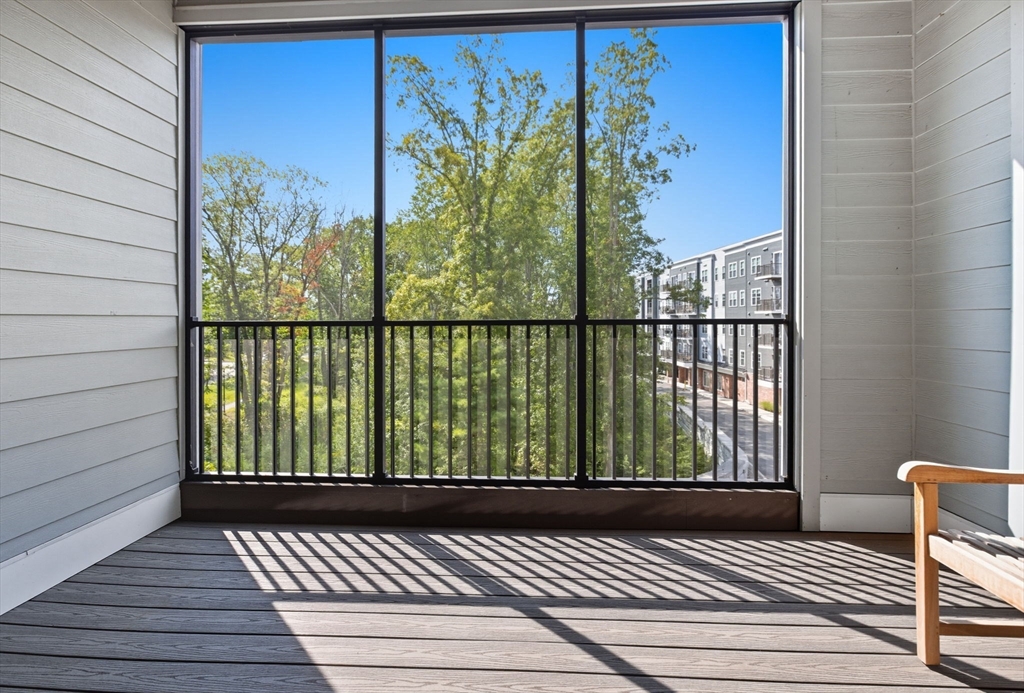 60 Coppersmith Way, Unit 208 Canton, MA 02021 - Photo 13 of 23 a view of a balcony with wooden floor and fence