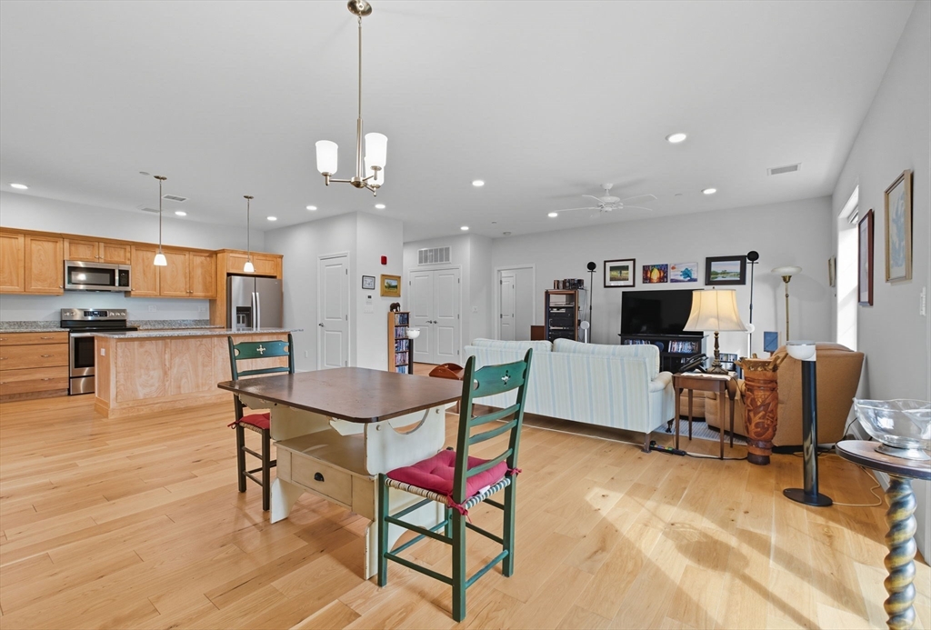 60 Coppersmith Way, Unit 208 Canton, MA 02021 - Photo 6 of 23 a living room with furniture a dining table and a flat screen tv