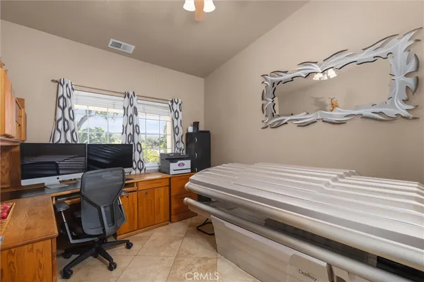 a view of a workspace with furniture and a window