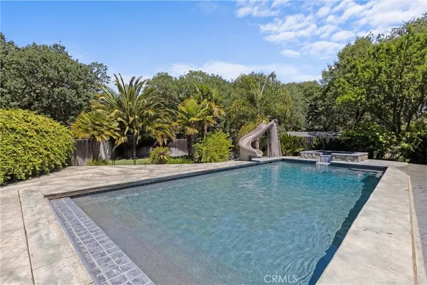 a view of house with garden and a sitting area