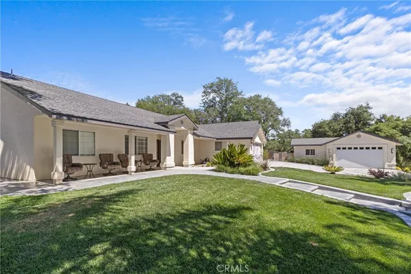 an aerial view of a house having patio with a table and chairs