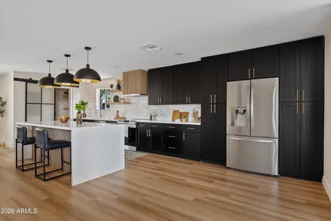 a kitchen with kitchen island white cabinets and refrigerator