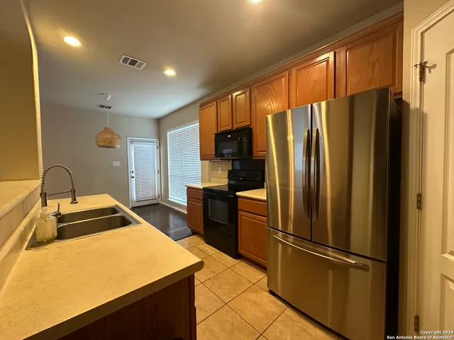 a kitchen with stainless steel appliances granite countertop a refrigerator stove and sink