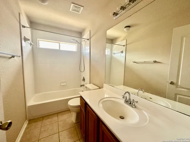 a bathroom with a tub sink toilet and a mirror