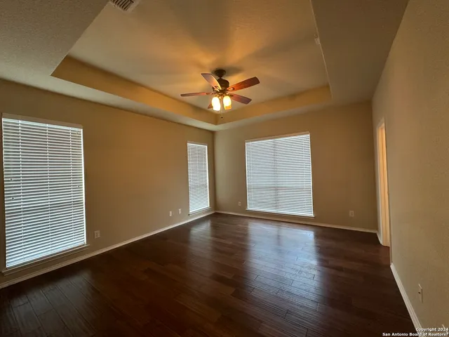 a view of an empty room with window and wooden floor