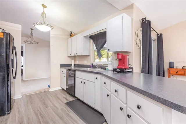 a kitchen with stainless steel appliances sink refrigerator and cabinets