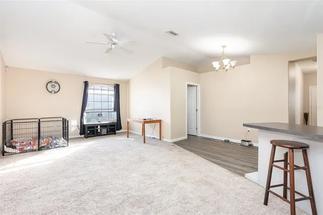 an empty room with windows and a chandelier