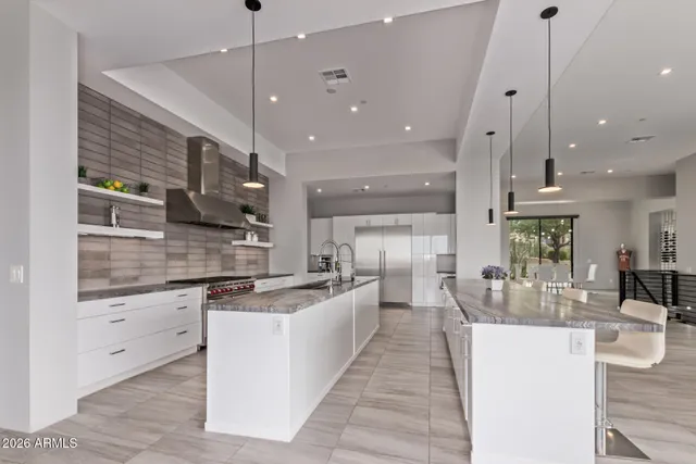 a large kitchen with stainless steel appliances lots of counter space and a sink