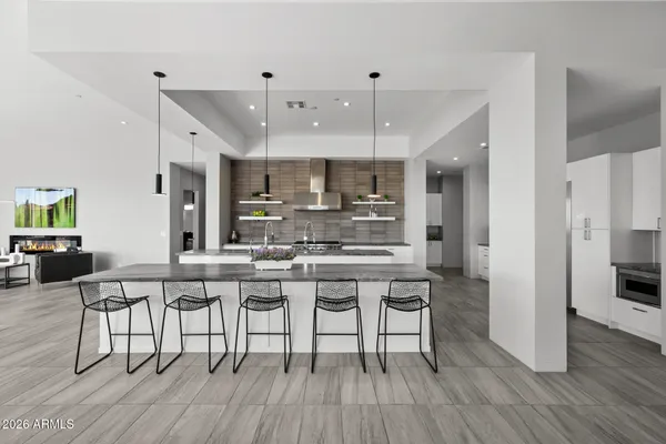 a kitchen with stainless steel appliances a dining table chairs stove microwave and cabinets