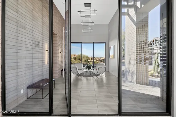 a large white kitchen with a large counter top space a sink stainless steel appliances and cabinets