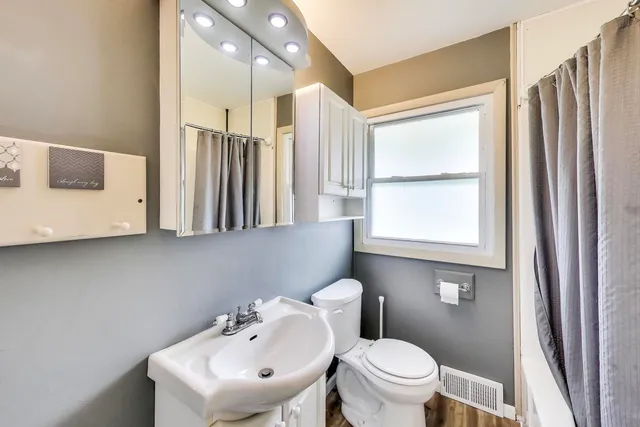 a bathroom with a sink a toilet and a mirror