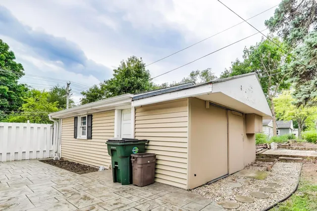 a backyard of a house with wooden fence and barbeque oven