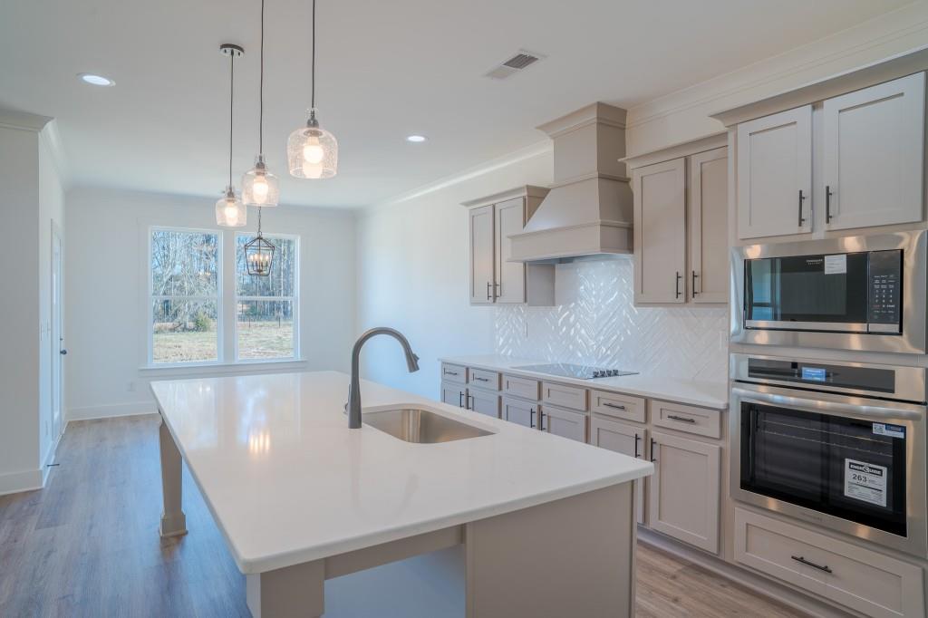 93 Tomahawk Trail Good Hope, GA 30641 - Photo 21 of 61 a kitchen with stainless steel appliances a sink a stove a microwave a center island and cabinets
