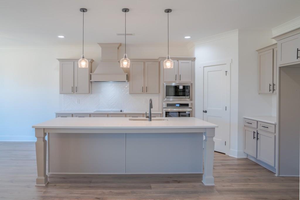 93 Tomahawk Trail Good Hope, GA 30641 - Photo 22 of 61 a kitchen with kitchen island a sink a stove a refrigerator and white cabinets