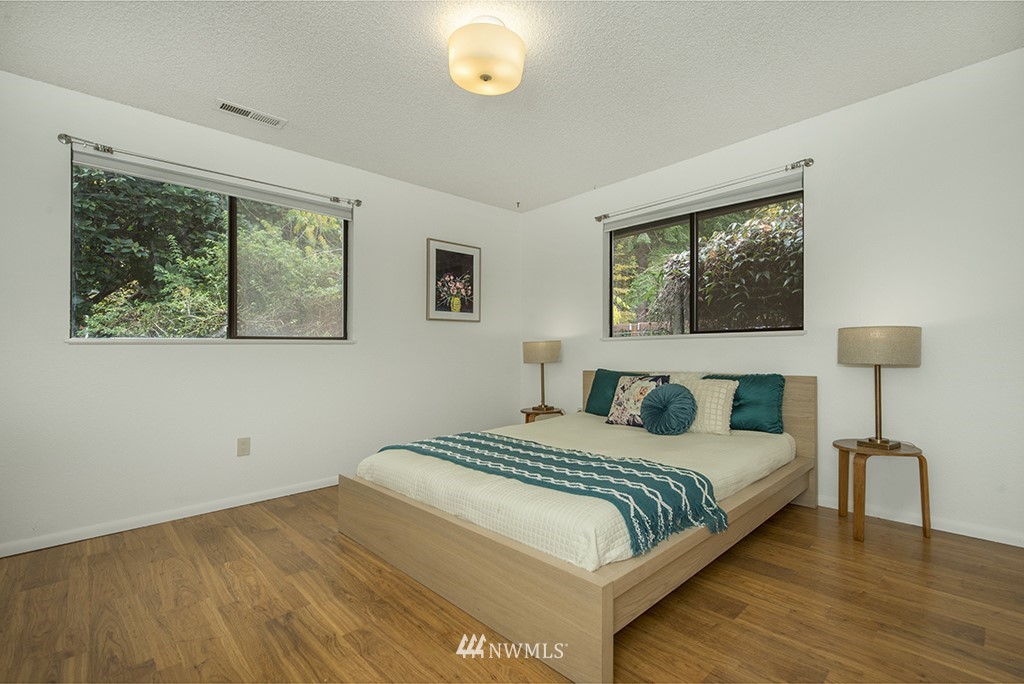 4336 Southwest Luana Beach Road Vashon, WA 98070 - Photo 16 of 40 a bedroom with a bed and a painting on the wall