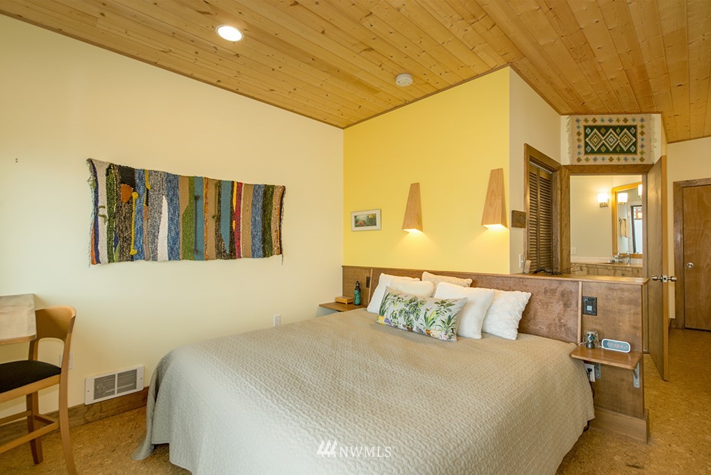 4336 Southwest Luana Beach Road Vashon, WA 98070 - Photo 23 of 40 a bedroom with a bed and wooden floor