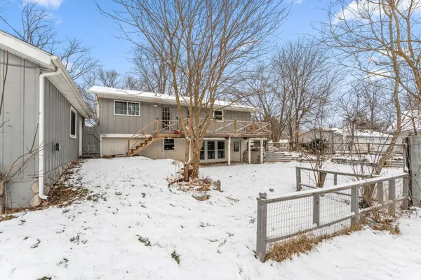 a view of a house with a yard covered in snow