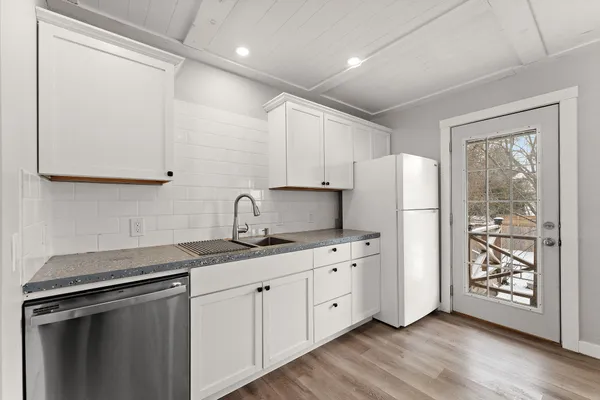 a kitchen with stainless steel appliances granite countertop a refrigerator sink and stove