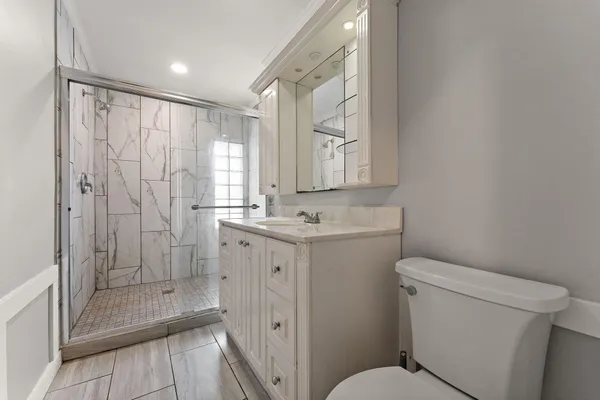 a bathroom with a granite countertop sink a mirror and a toilet