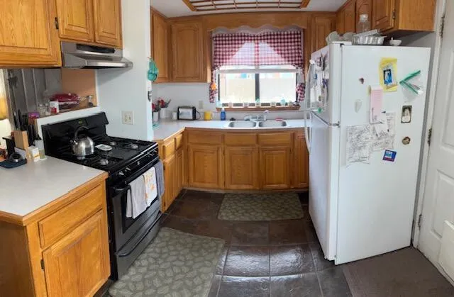 a kitchen with stainless steel appliances granite countertop a refrigerator and a stove