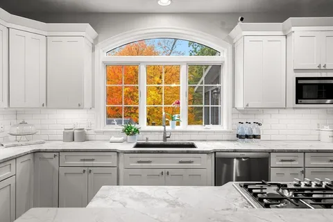 a kitchen with stainless steel appliances kitchen island granite countertop a sink and a stove