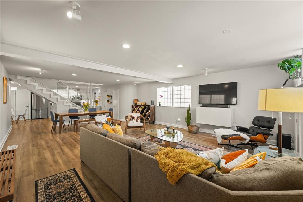 a living room with furniture a wooden floor and a flat screen tv