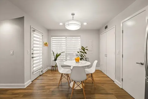 a view of a dining room with furniture a chandelier and wooden floor
