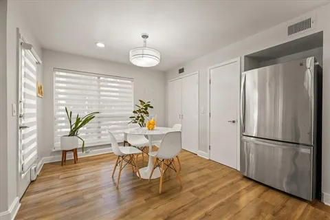 a view of a hallway with wooden floor and a bathroom