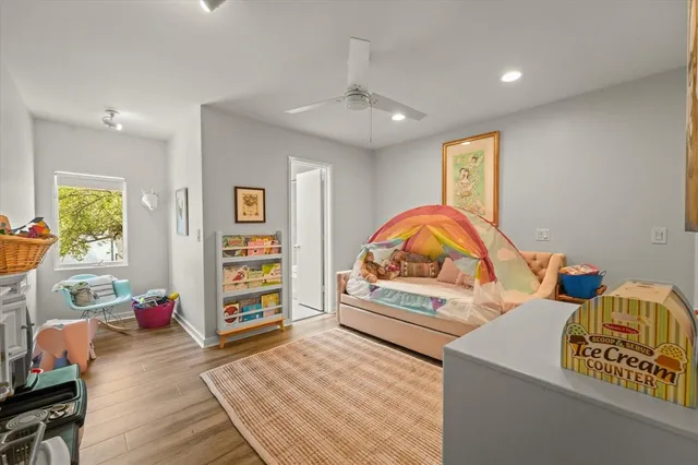 a view of a bedroom with furniture and wooden floor