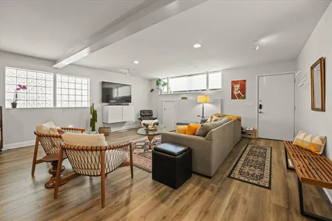 a living room with furniture and a wooden floor
