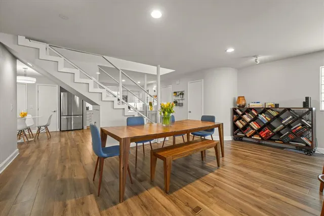 a living room with furniture a wooden floor and next to a window