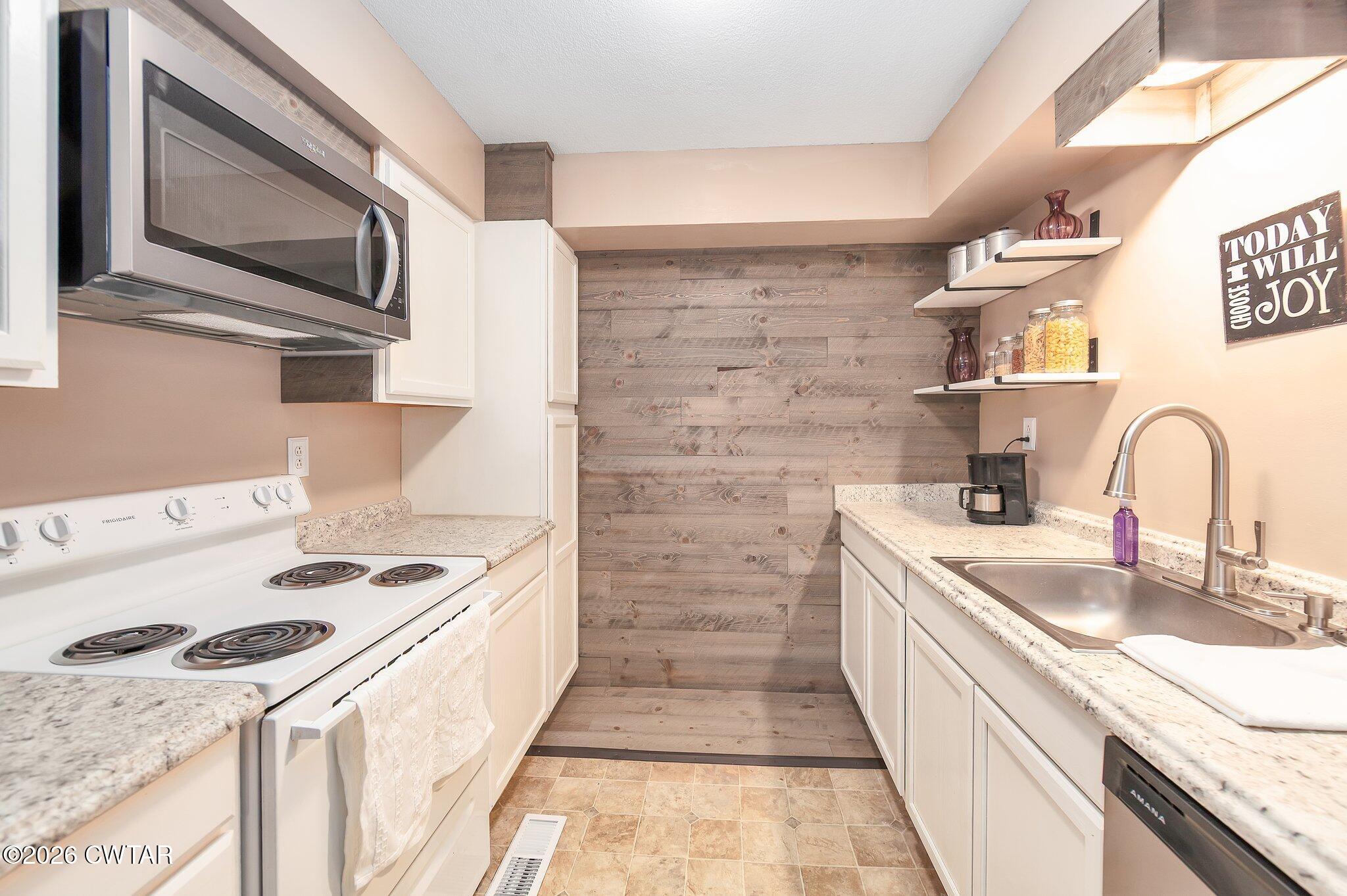 101 Wilde Road Pinson, TN 38366 - Photo 7 of 16 a kitchen with stainless steel appliances granite countertop a sink stove and microwave