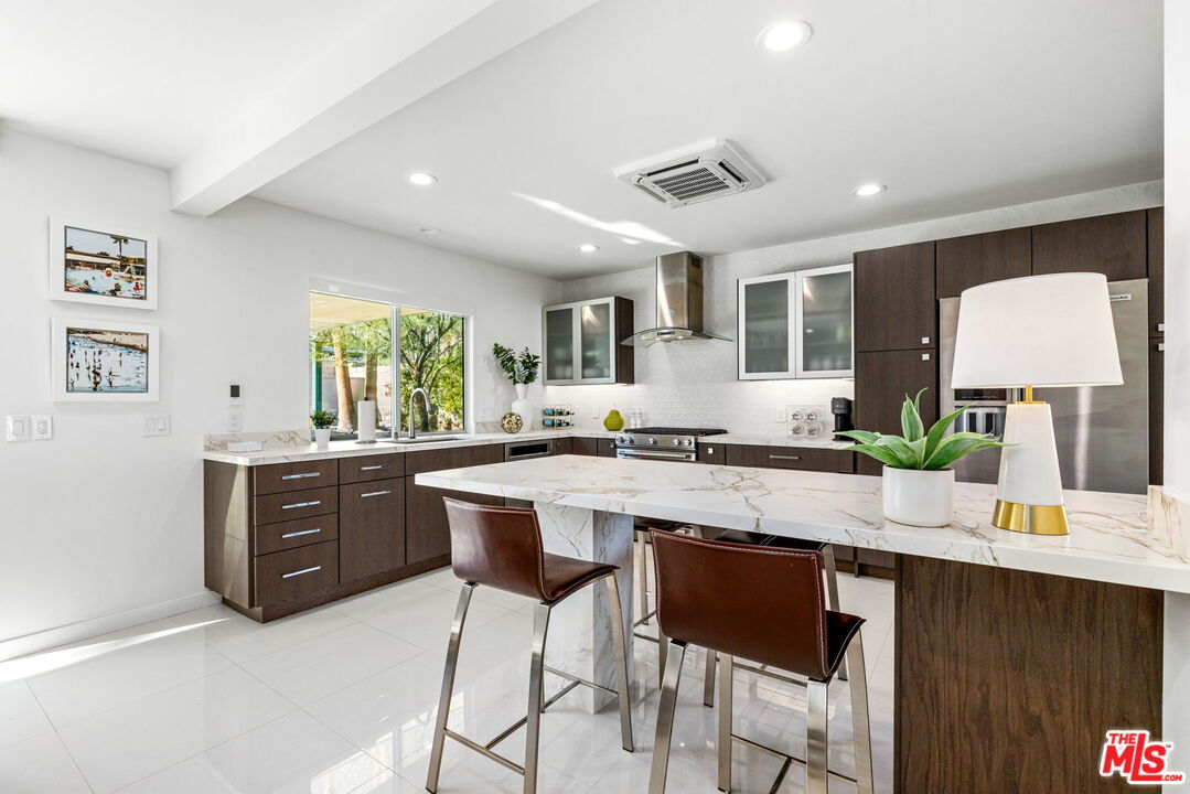 71581 Halgar Road Rancho Mirage, CA 92270 - Photo 15 of 39 a kitchen with a sink a counter top space and living room view
