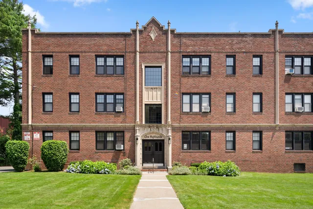 front view of a brick house with a yard