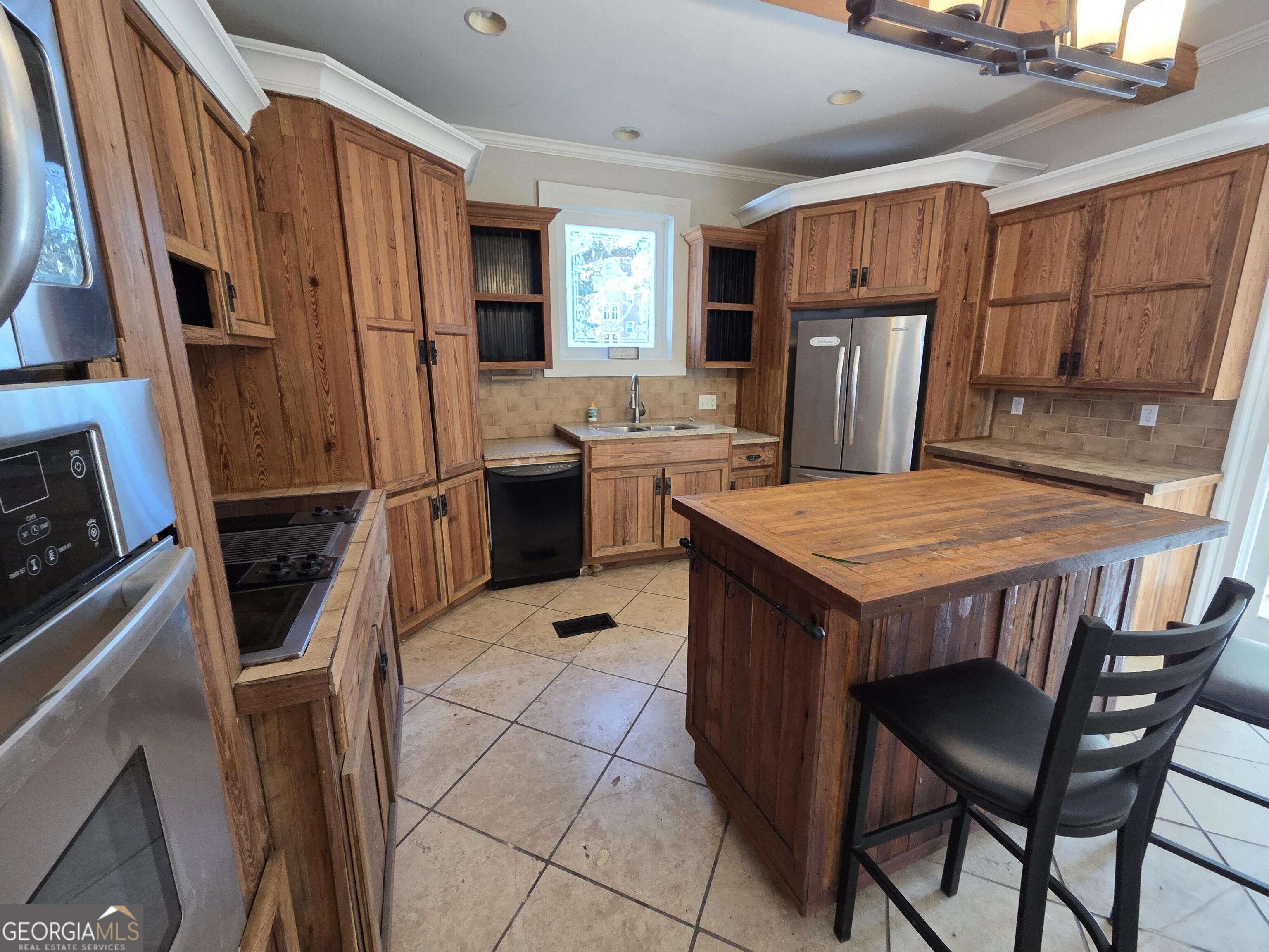 520 Ellis Street Brunswick, GA 31520 - Photo 15 of 48 a kitchen with a refrigerator a stove top oven a sink and dishwasher